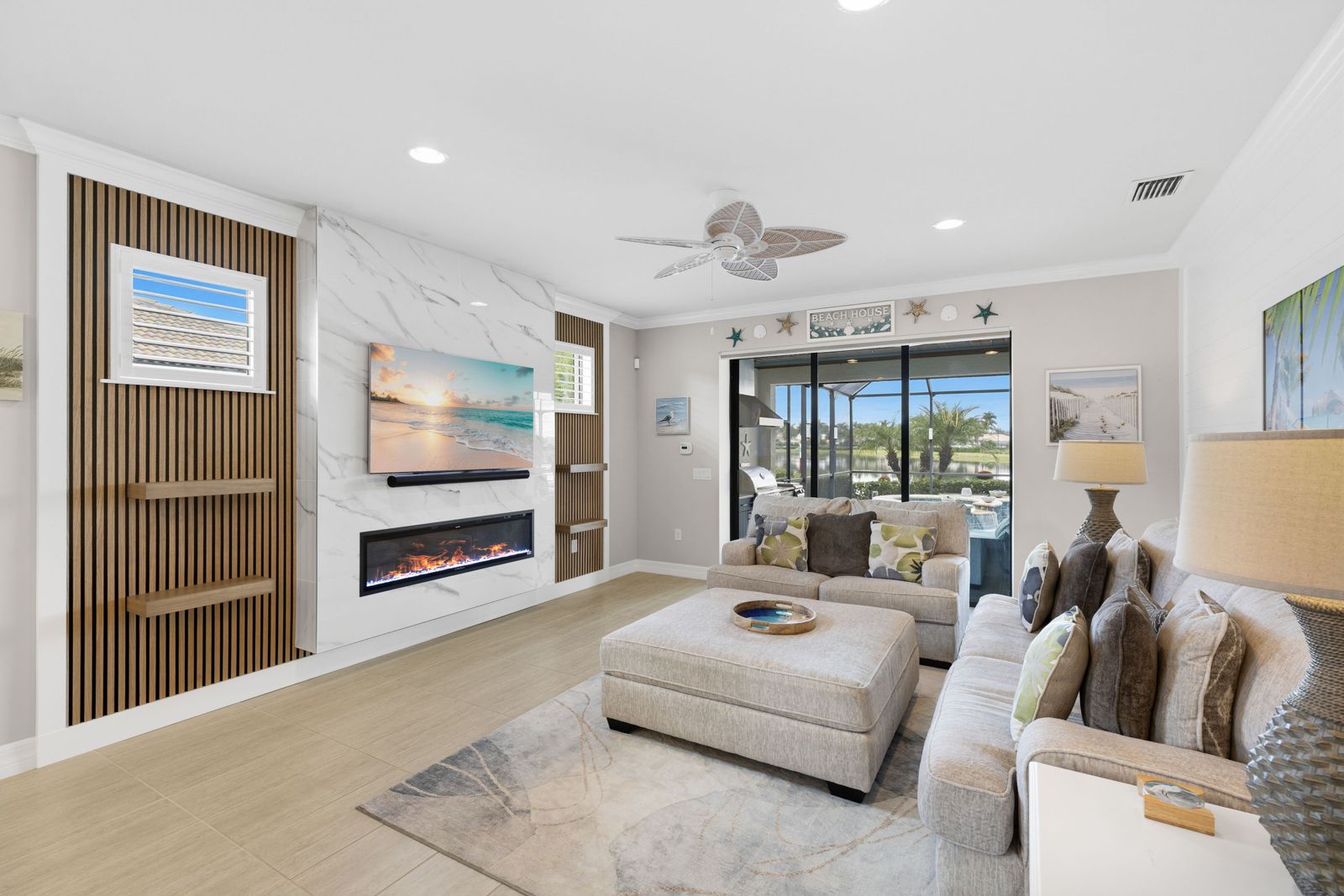 Media wall with a light center panel holding a TV and linear fireplace, flanked by a wood slat panel with floating shelves, in a living room in a Talon Preserve home